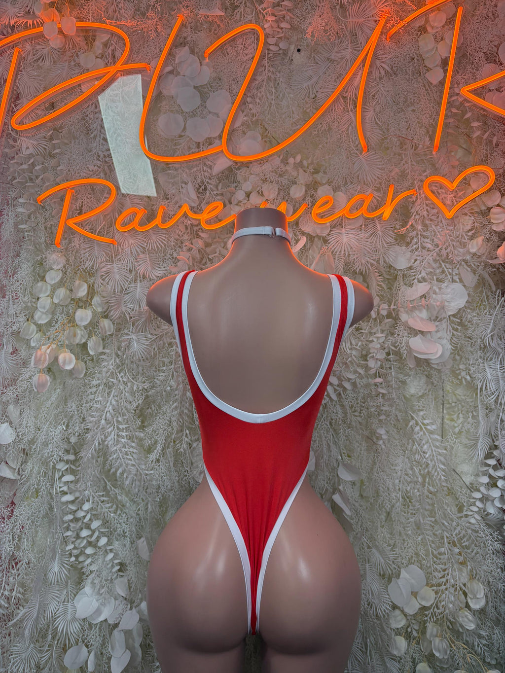 Back view of red one-piece bodysuit with white trim and neck choker