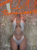White halter bodysuit with draped neckline and layered chain detail