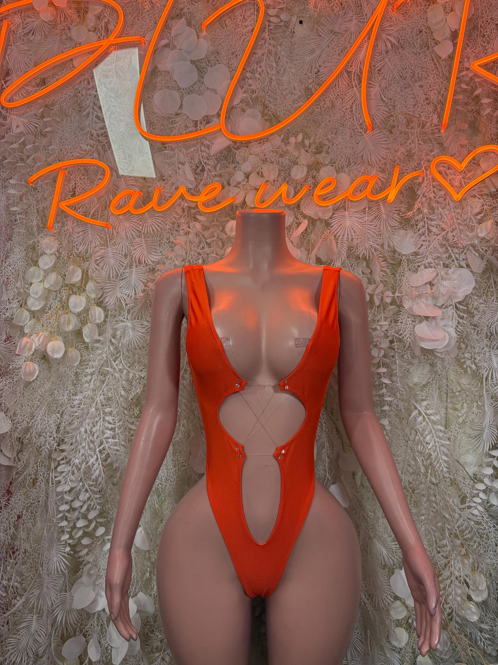Orange one-piece bodysuit with deep V front and high-cut legs, metal ring at chest