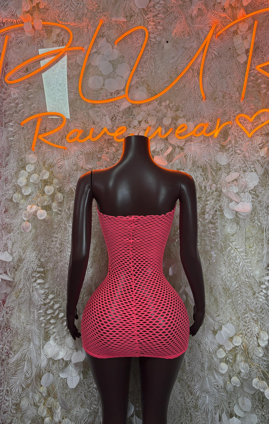 Pink fishnet mini dress with open back on mannequin