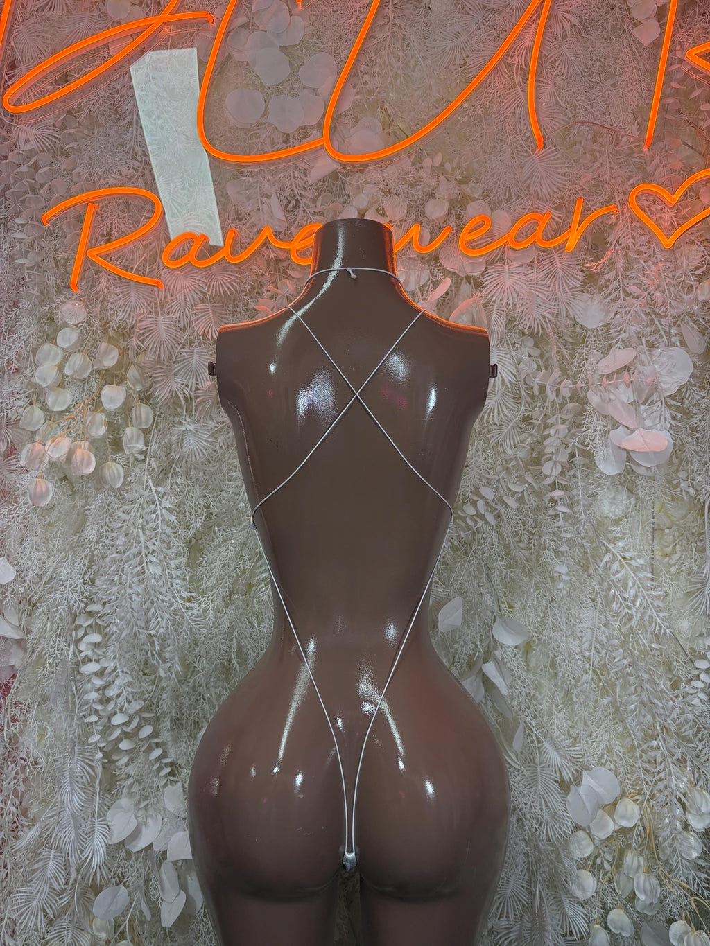 White mesh bodysuit with crisscross back straps and thong bottom, on mannequin