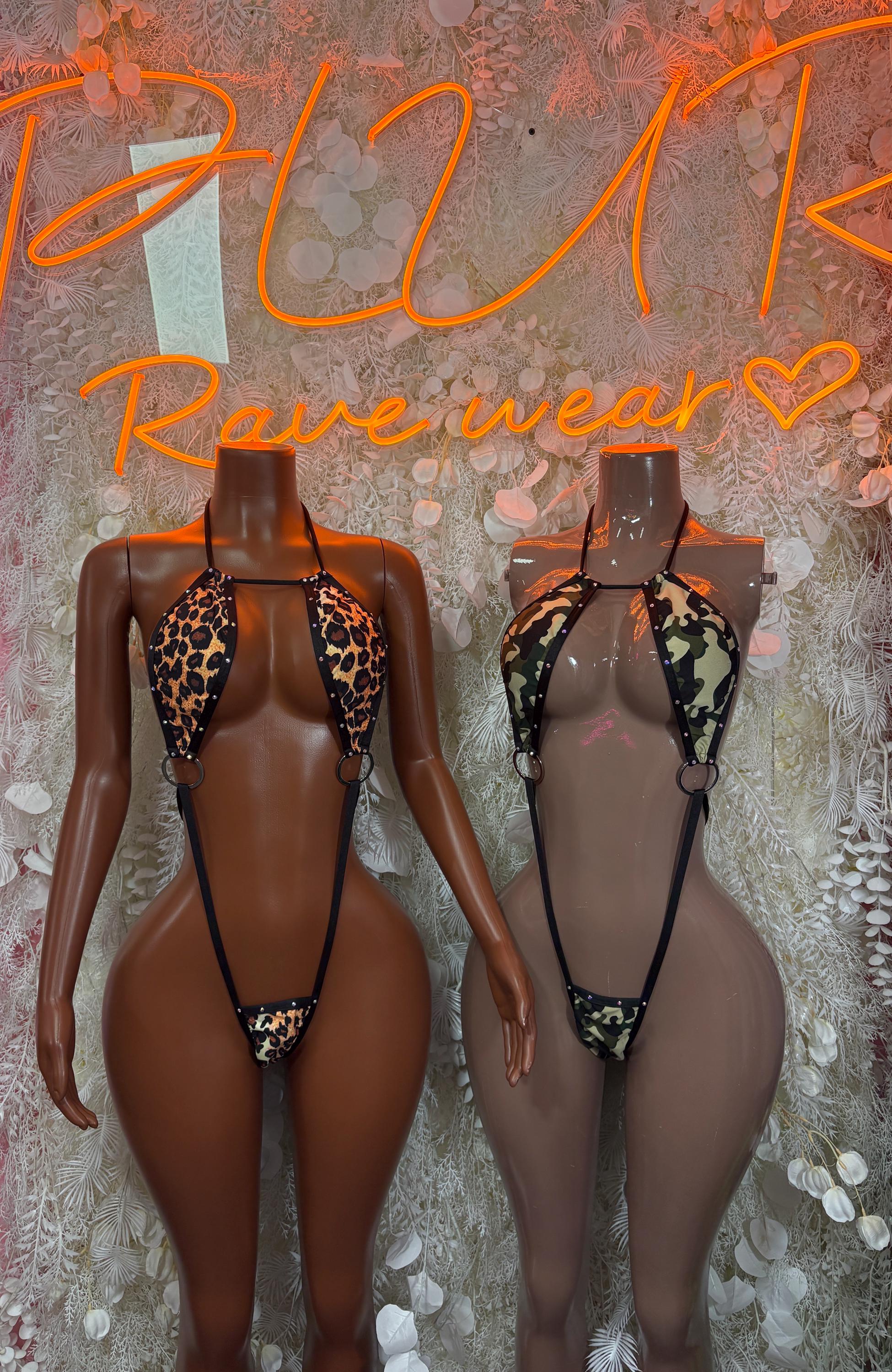Two black one-piece festival bodysuits with leopard-print panels and thin harness straps