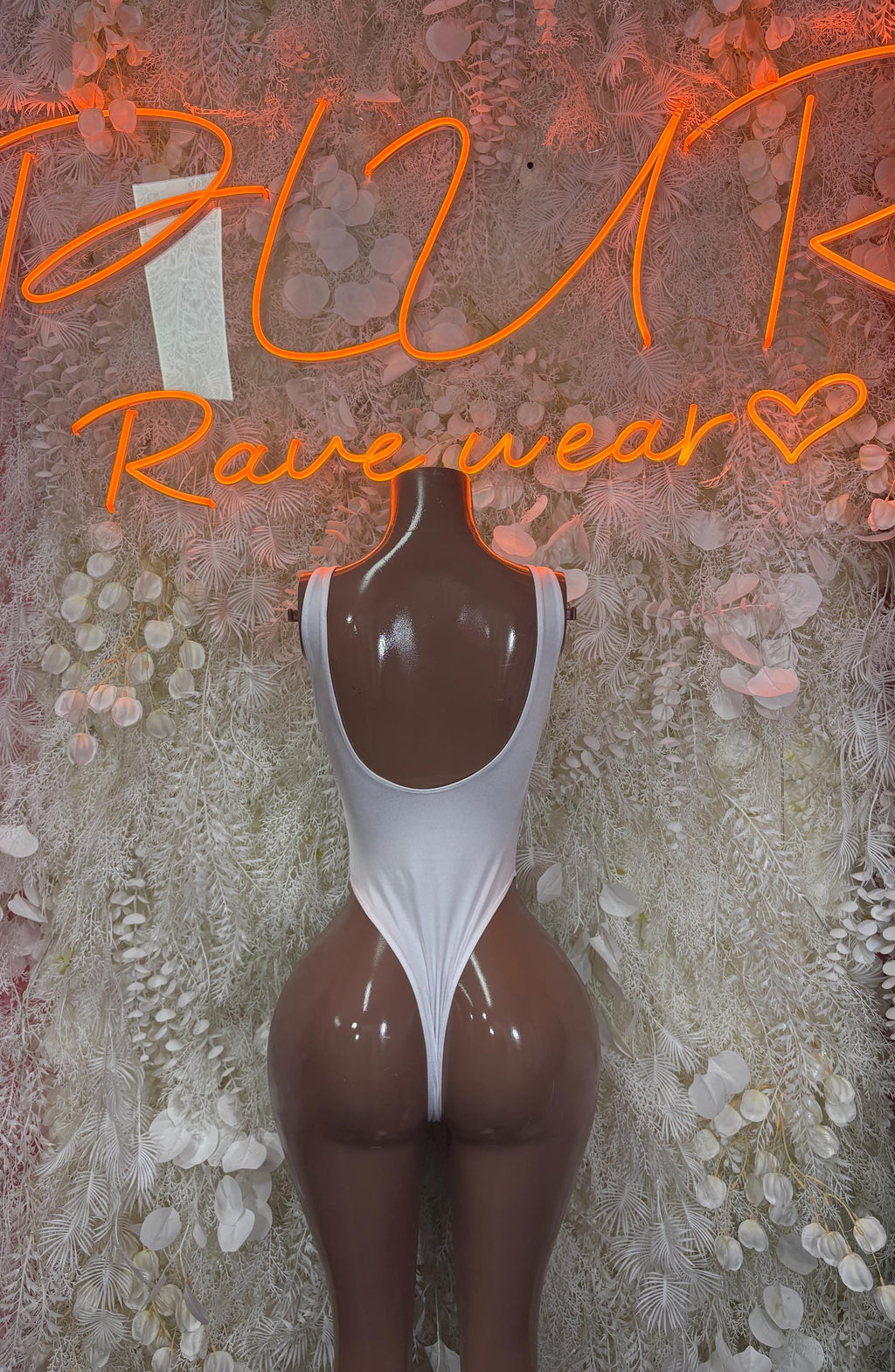White cutout bodysuit with scooped neckline and side cutouts, high-leg fit
