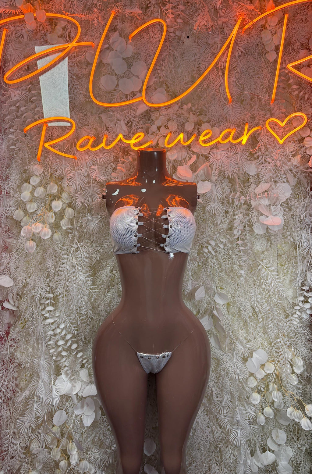 Silver metallic bikini with triangle-style top and skimpy bottoms, close-up on mannequin