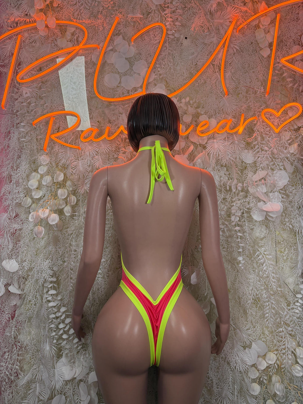 Back view halter one-piece bodysuit in neon coral and neon green with neck tie