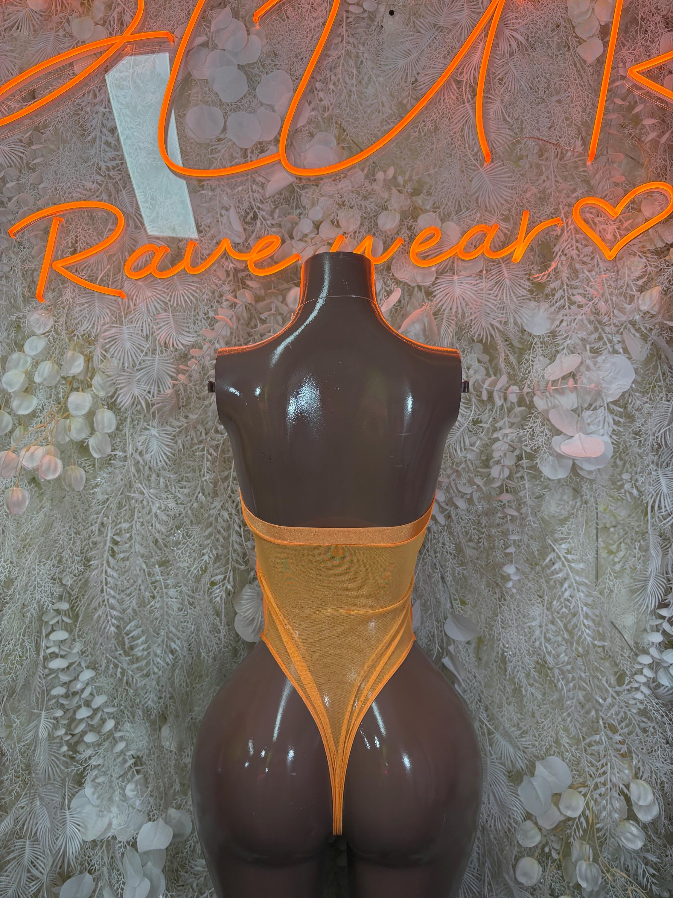 Orange one-piece bodysuit with open back and black sheer lower panels