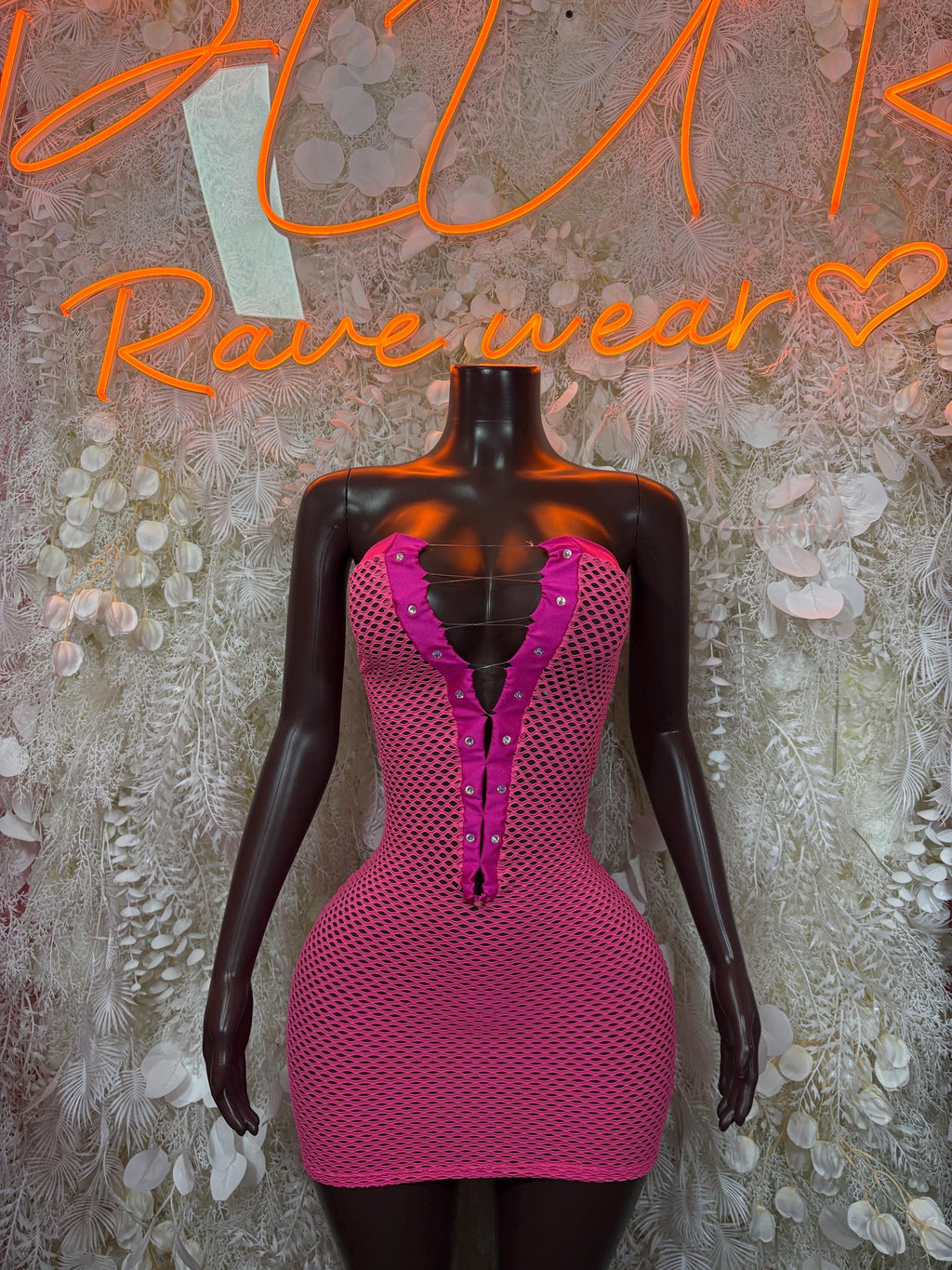 Pink fishnet mini dress with deep V neckline and front zipper on mannequin