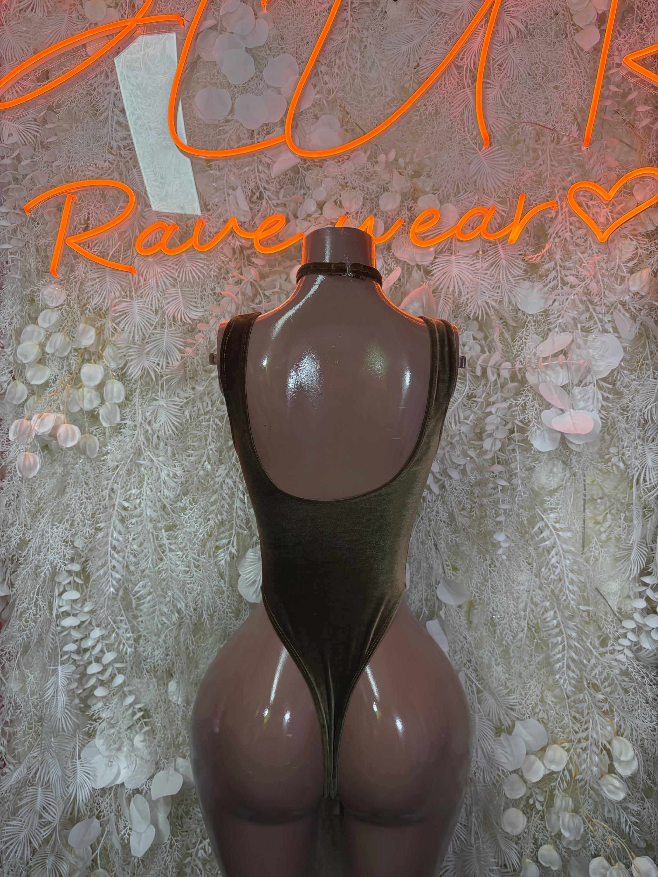 Dark olive-green velvet one-piece bodysuit with backless cutout and halter straps.