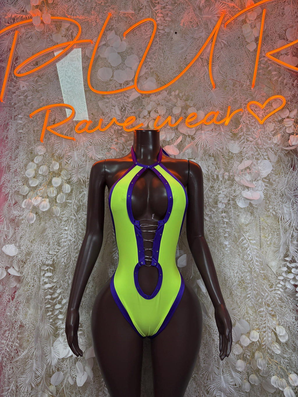 Neon green and blue halter bodysuit with high-cut legs and oval cutout details