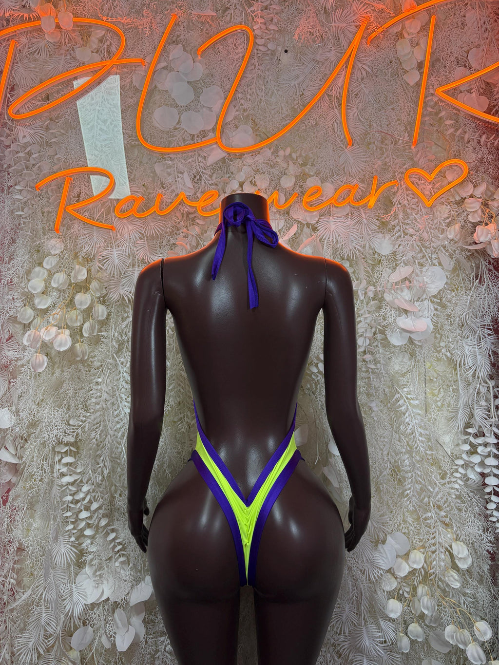 Neon green and blue backless halter bodysuit with tie closure and high-cut legs