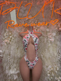 One-piece slingshot swimsuit, white with pink heart-and-text print and narrow legs