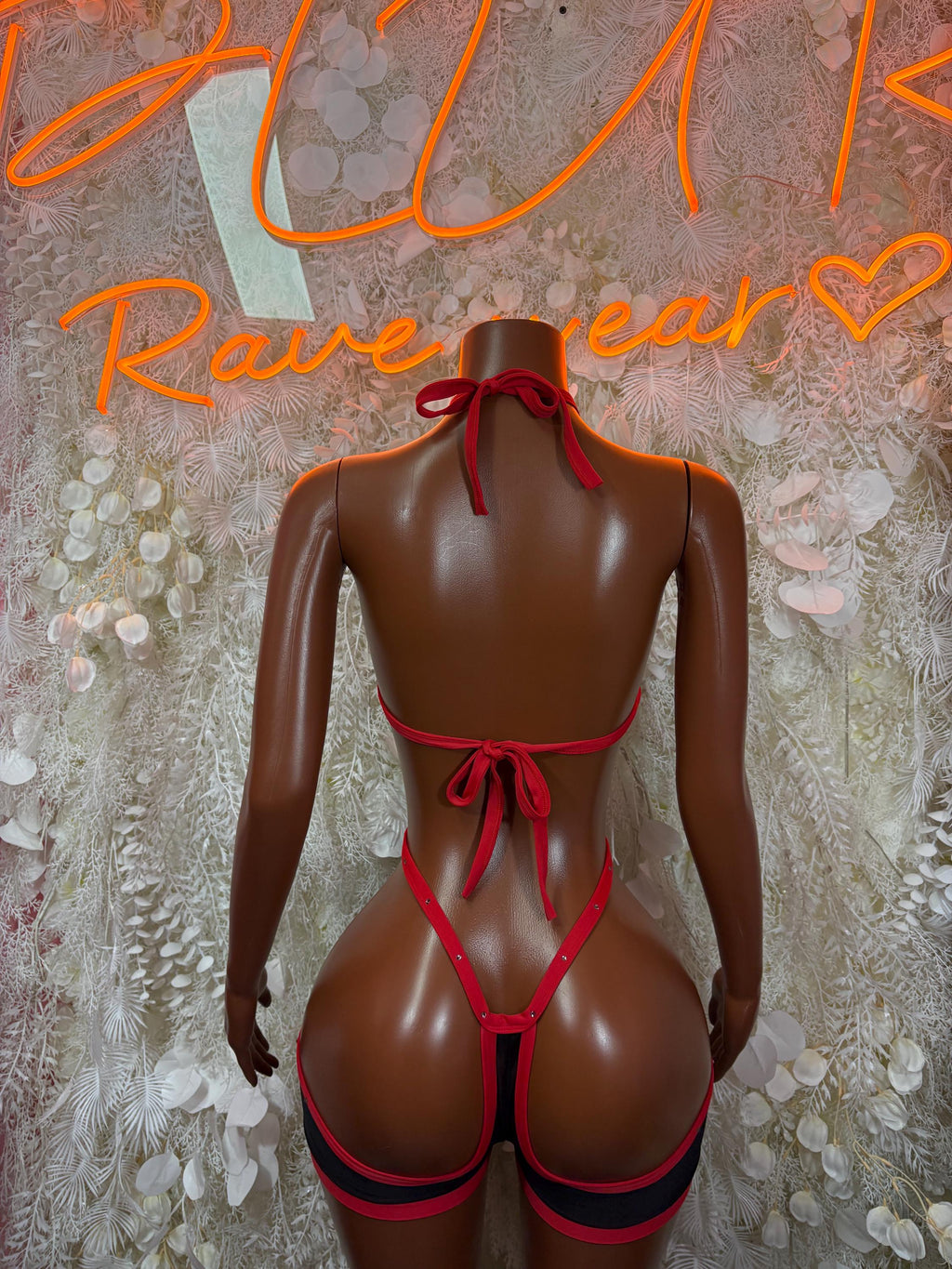 Red-and-black backless harness bodysuit with tie straps and bow