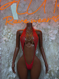 Red strappy rave bodysuit with chain necklace and low-cut briefs