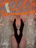 Black one-piece bodysuit with deep V neckline and chest cutout
