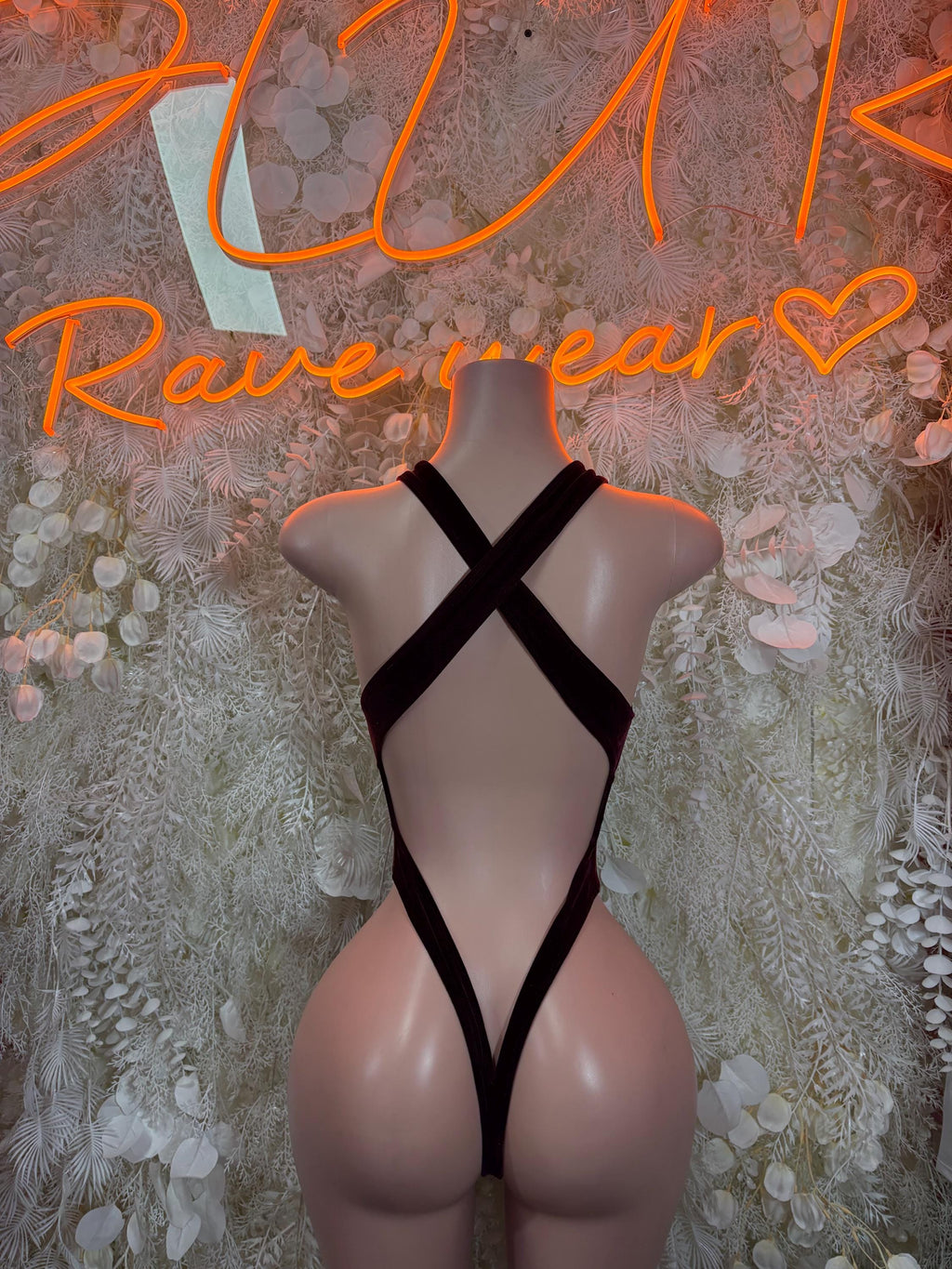 Black one-piece bodysuit with crisscross back straps and high-cut leg