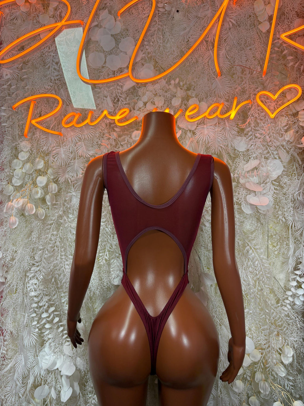 Burgundy V-neck cutout bodysuit with crisscross straps and high-cut leg openings