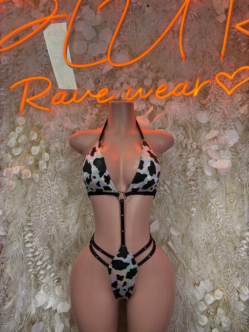 Black and white cow print bikini set with triangle top and high-cut bottoms, strappy ties