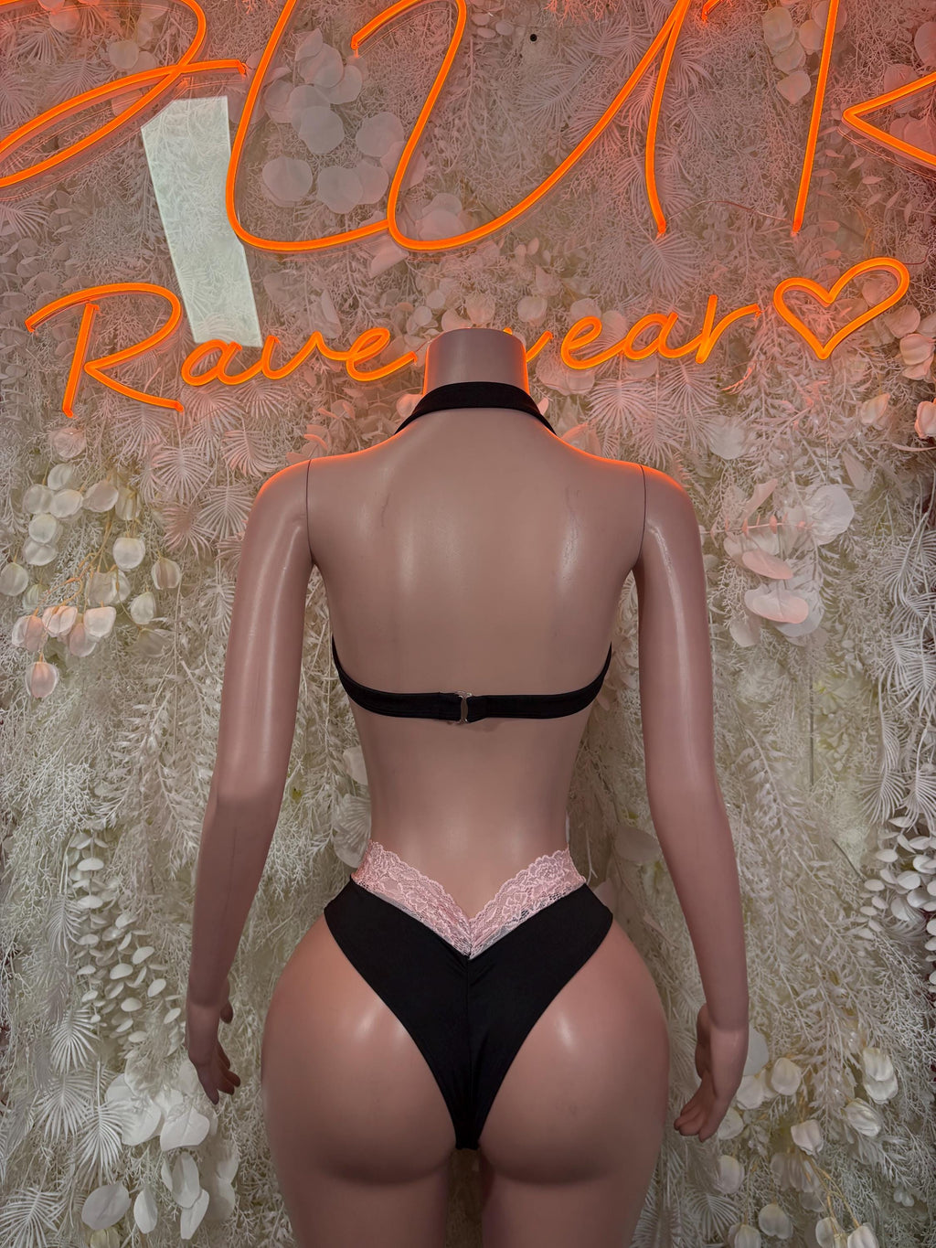 Two-piece lace festival set, back view: black bra with pink lace-trim bikini bottoms