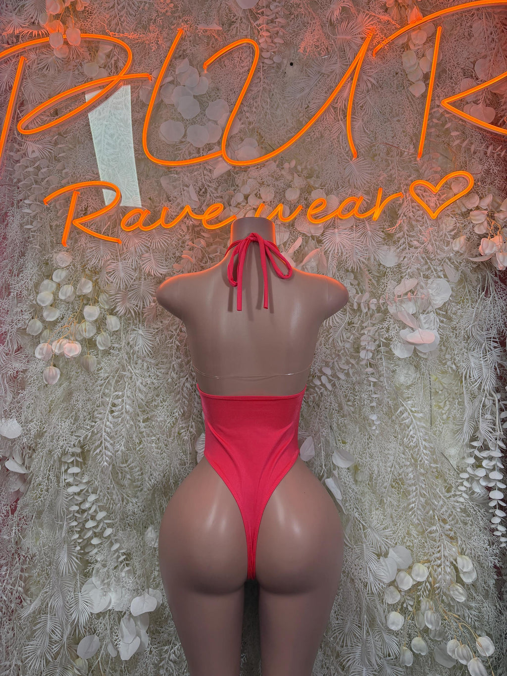 Coral pink backless dance bodysuit with crisscross tie straps on upper back.