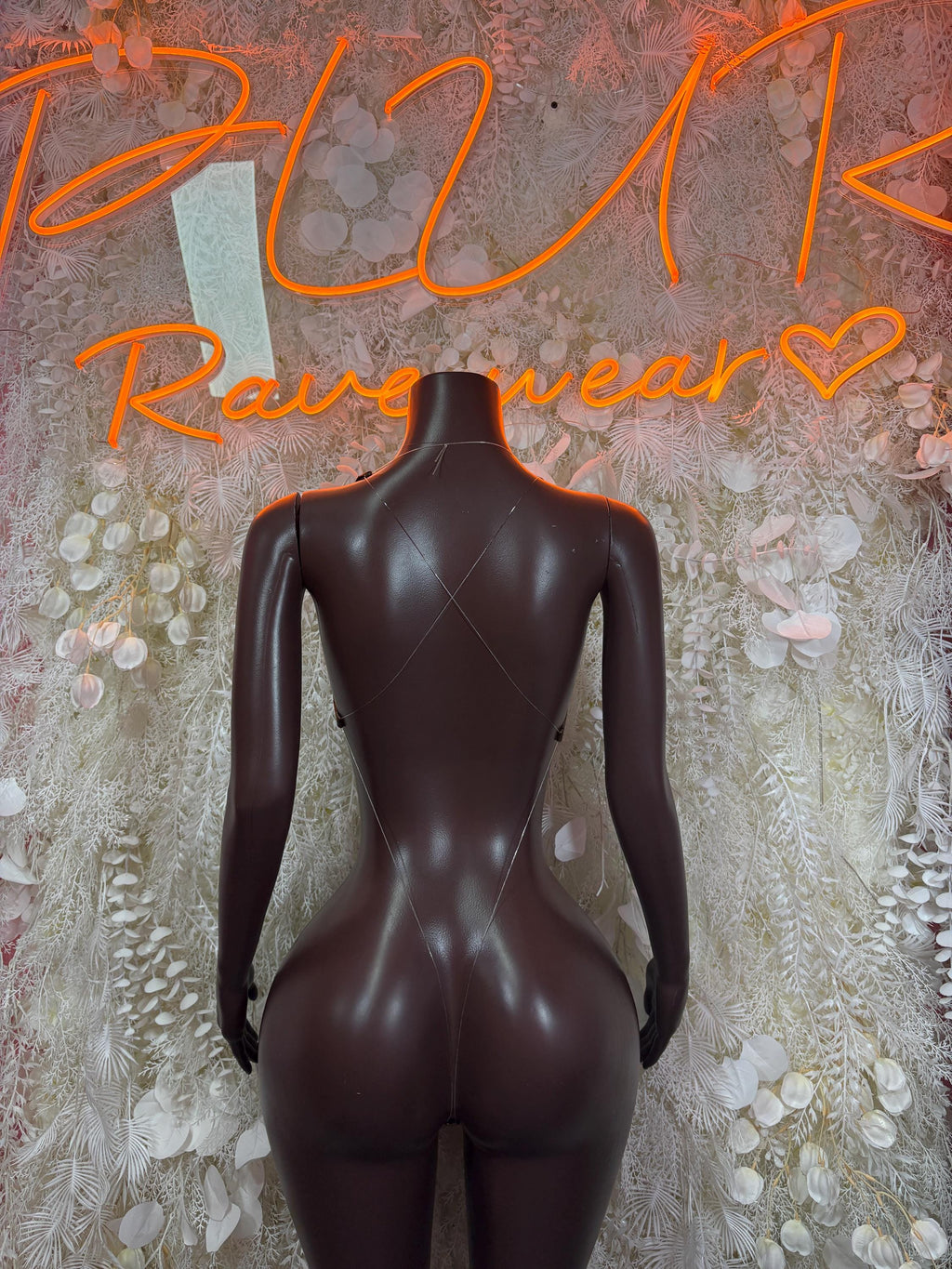 Metallic green bodysuit on mannequin, back view with crisscross straps