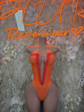 Orange V-neck halter bodysuit with central seam and sheer panels at sides