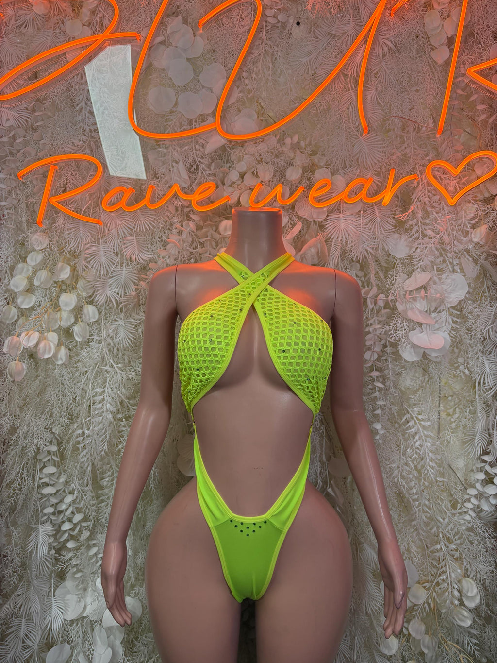 Neon green fishnet bodysuit with halter cutout and crisscross straps, high-cut legs