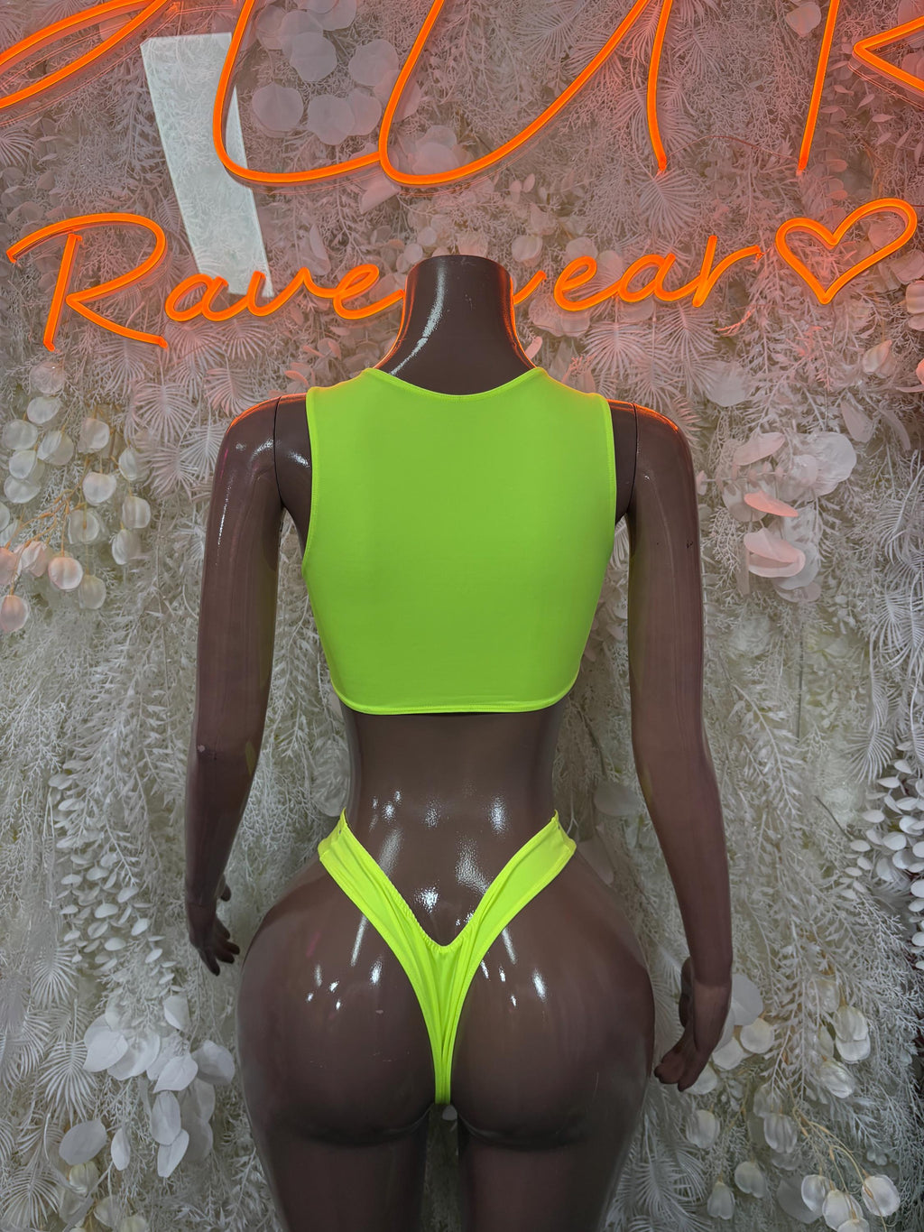Neon green sleeveless crop top and high-cut thong bottoms, front view on mannequin