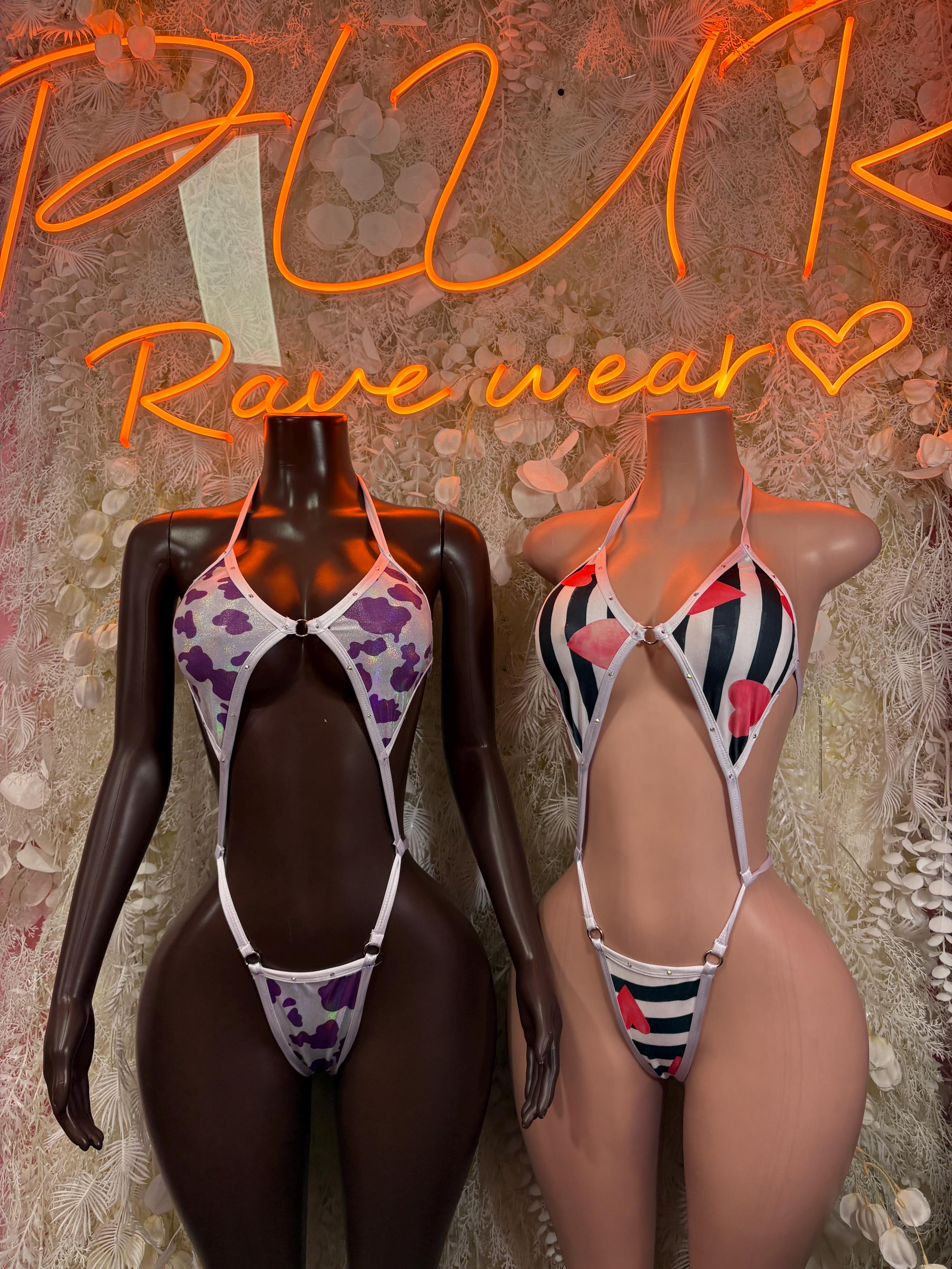 Two one-piece dance bodysuits: purple cow print and red/black striped halter
