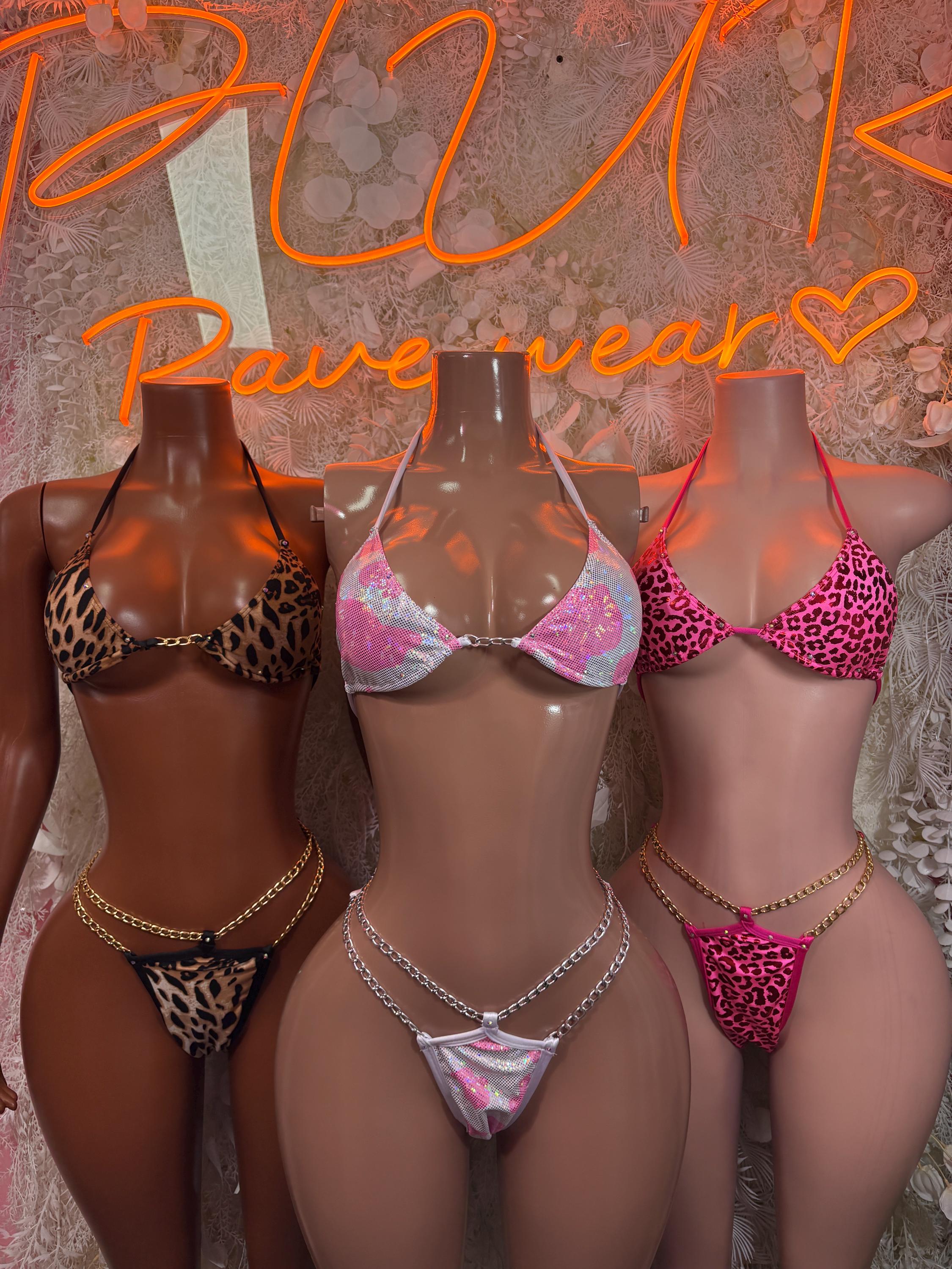 Three two-piece animal-print dancewear bodysuits on mannequins, chain-trim bikini sets