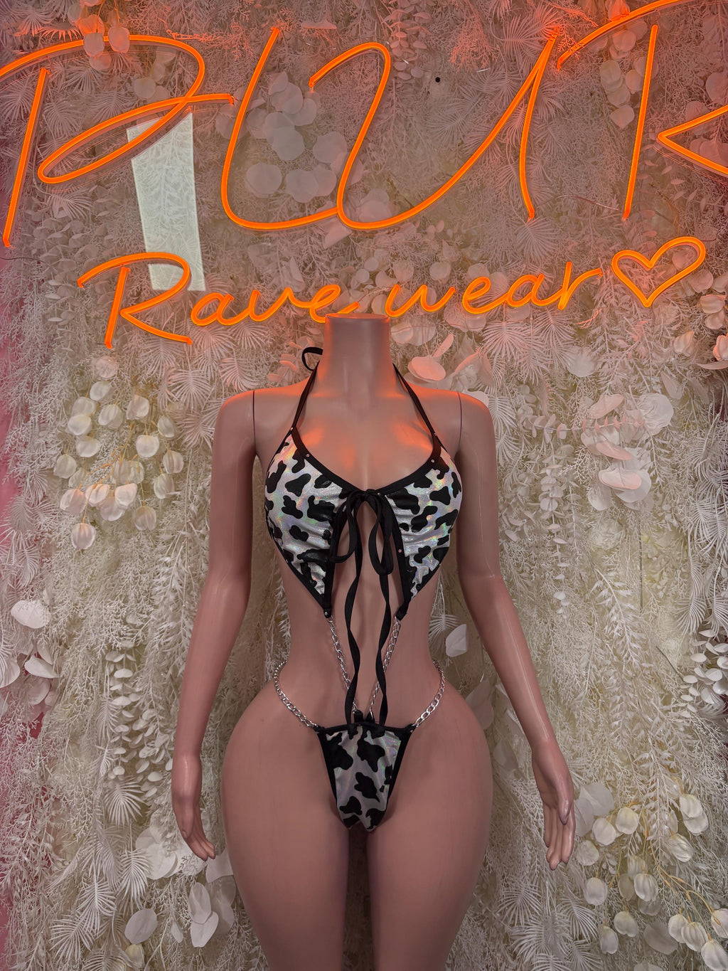 Cow print one-piece bodysuit with black lace-up front and cheeky cut