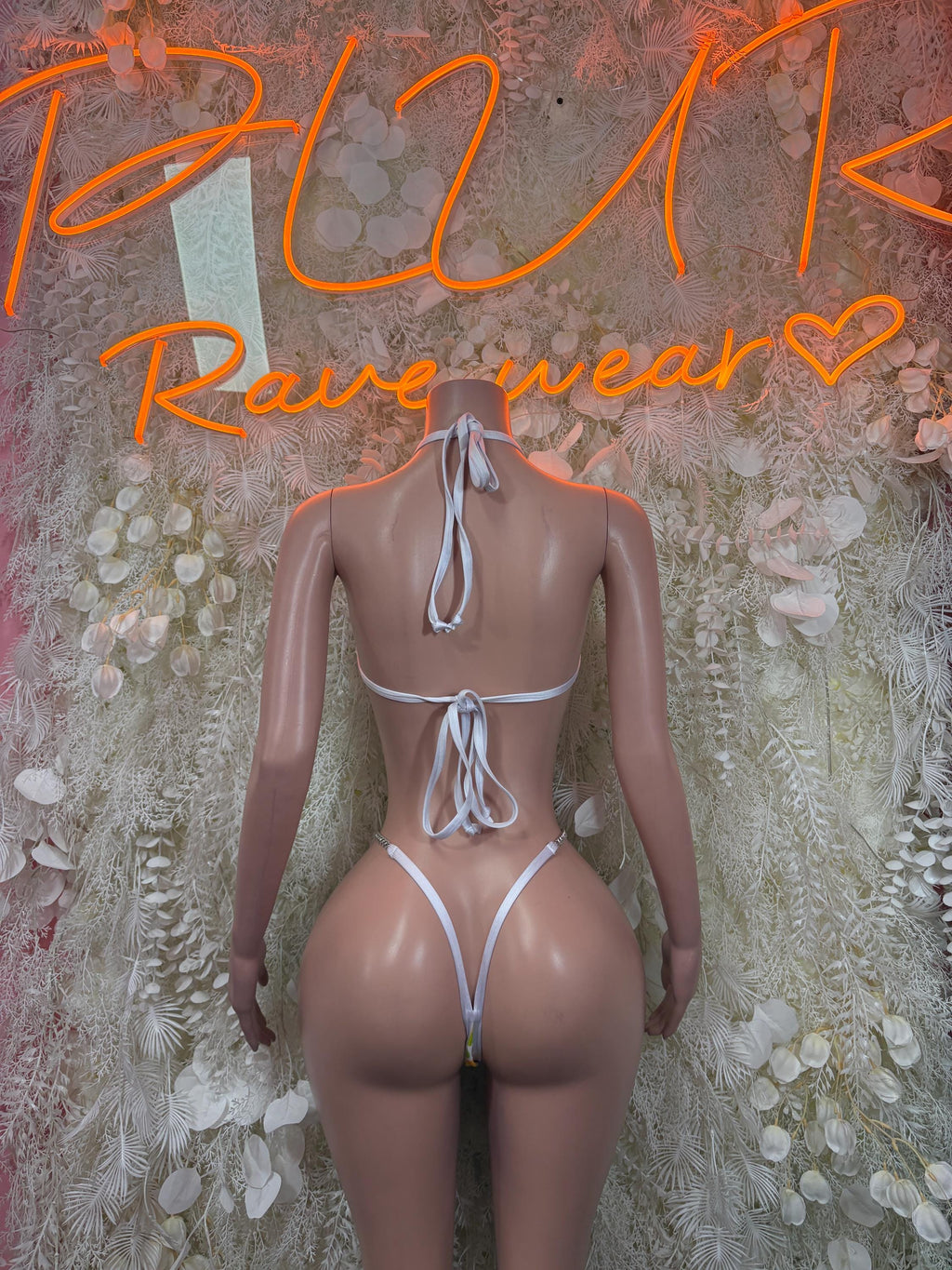 One-piece bodysuit with open back and white lace ties, minimal coverage