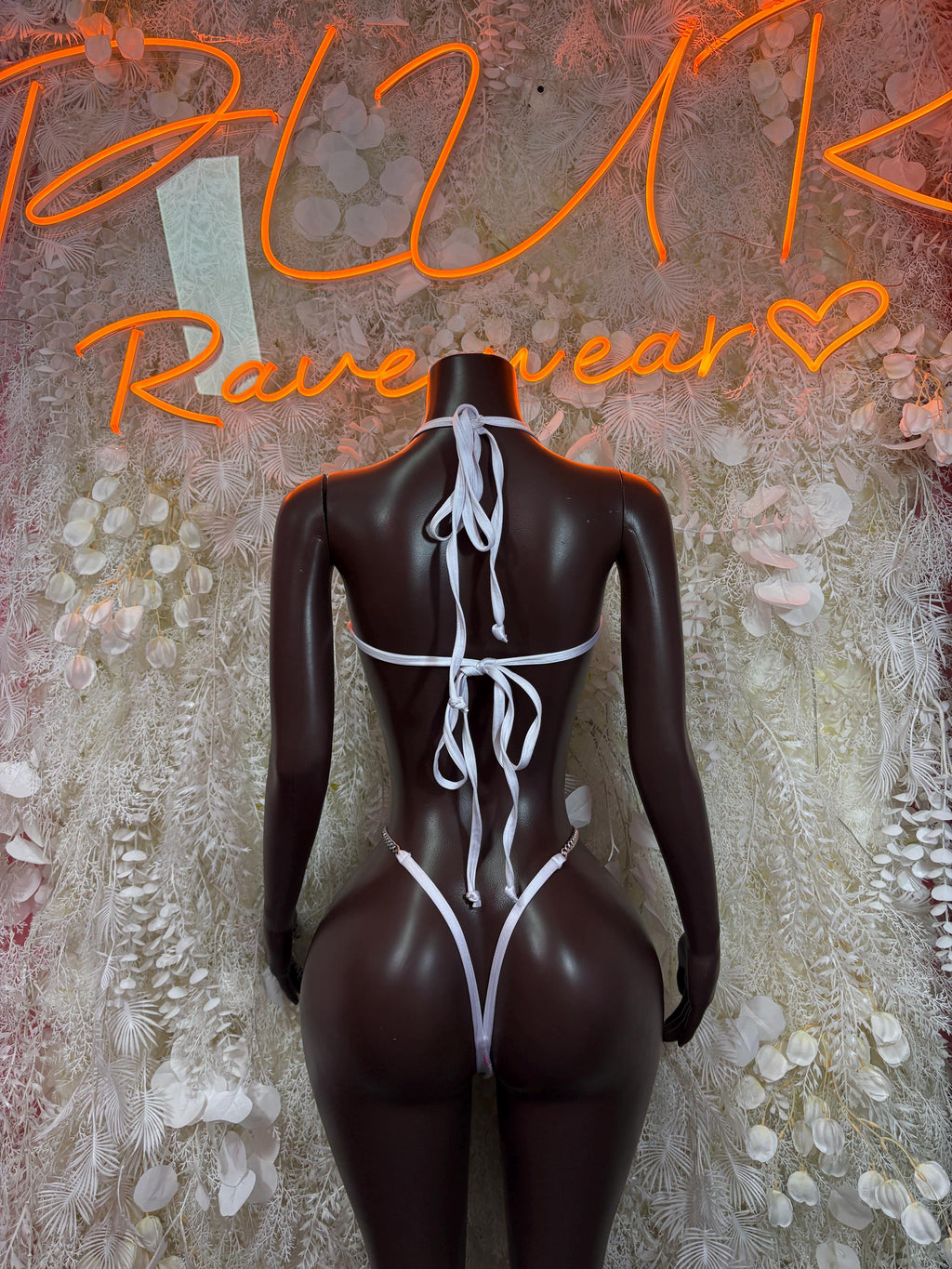 Cow-print one-piece bodysuit back view with crisscross lace-up straps and thong cut