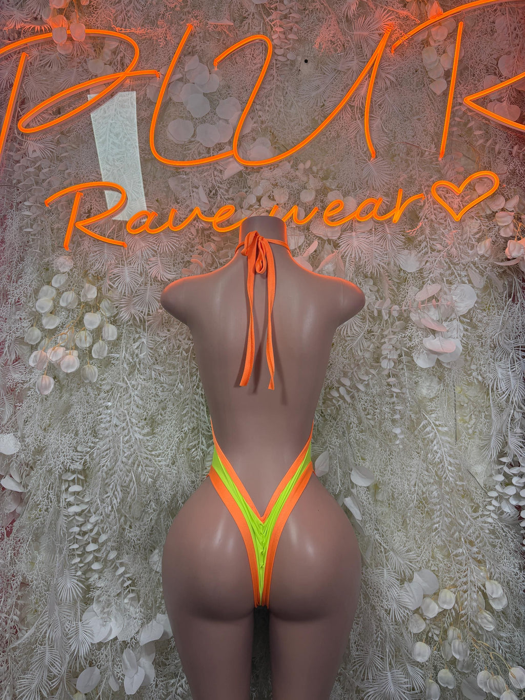 Neon green bodysuit with orange trim, halter back ties and high-cut