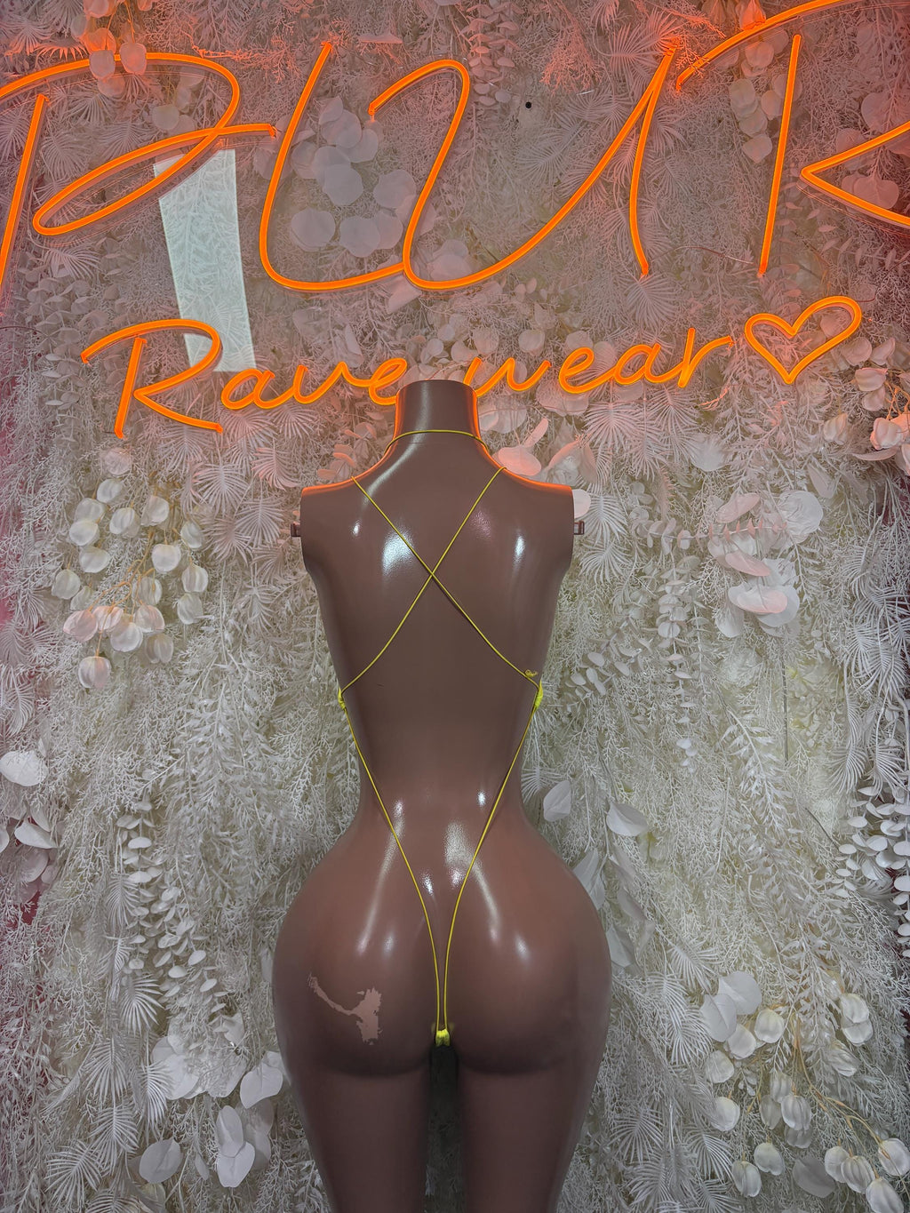 Back view yellow bodysuit with black trim and crisscross back straps