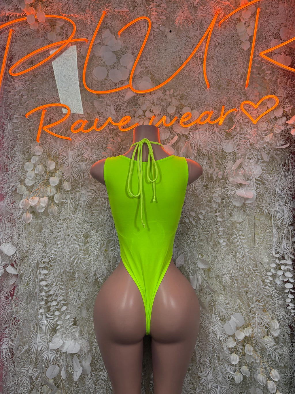 Neon green lace-up thong bodysuit with open back and high-cut legs