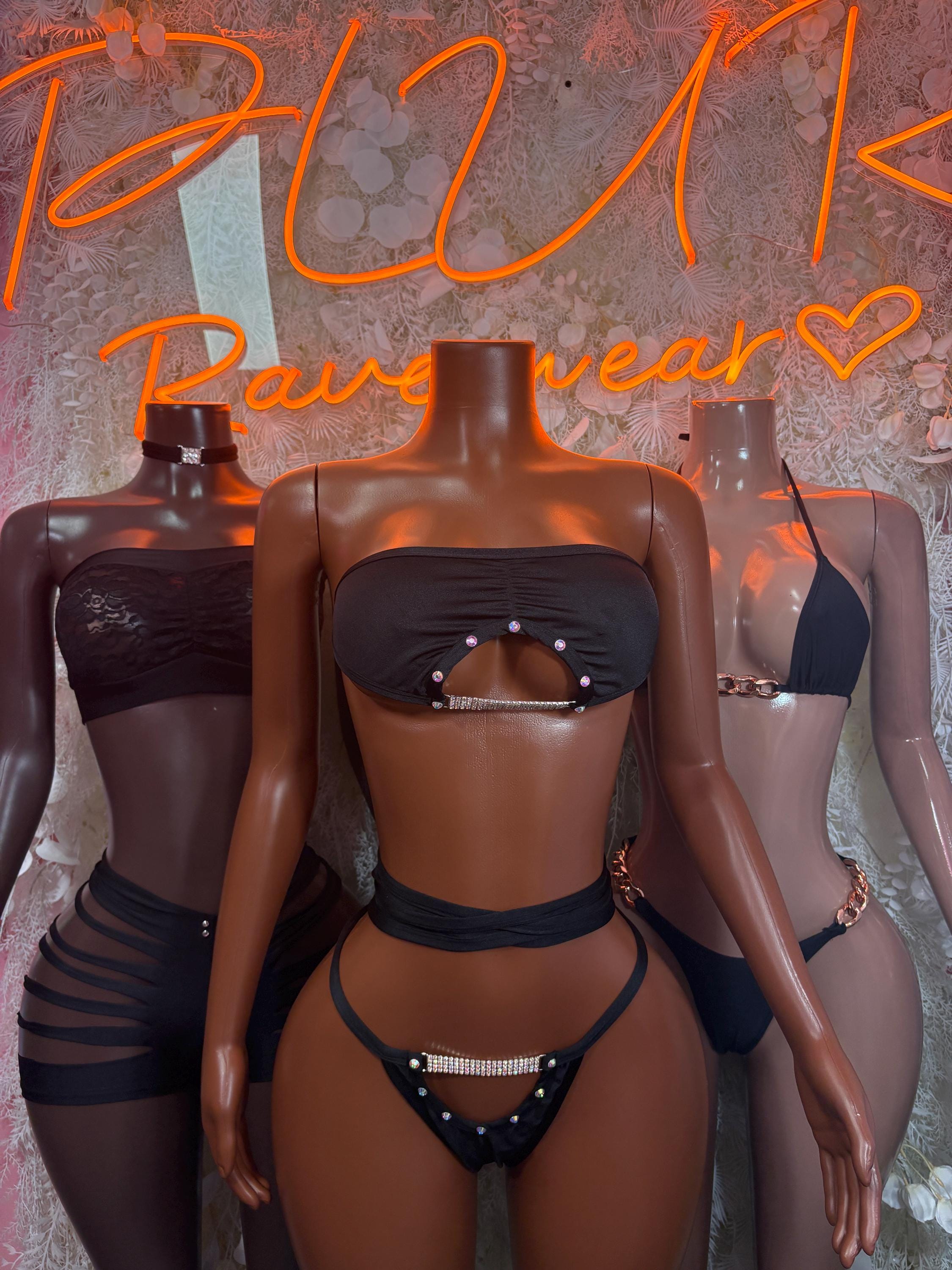 Black two-piece bodysuit with strapless bandeau top and high-rise bottoms, chain belt details