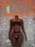 Black two-piece bodysuit set with strapless bandeau top and high-leg thong bottoms, chain details
