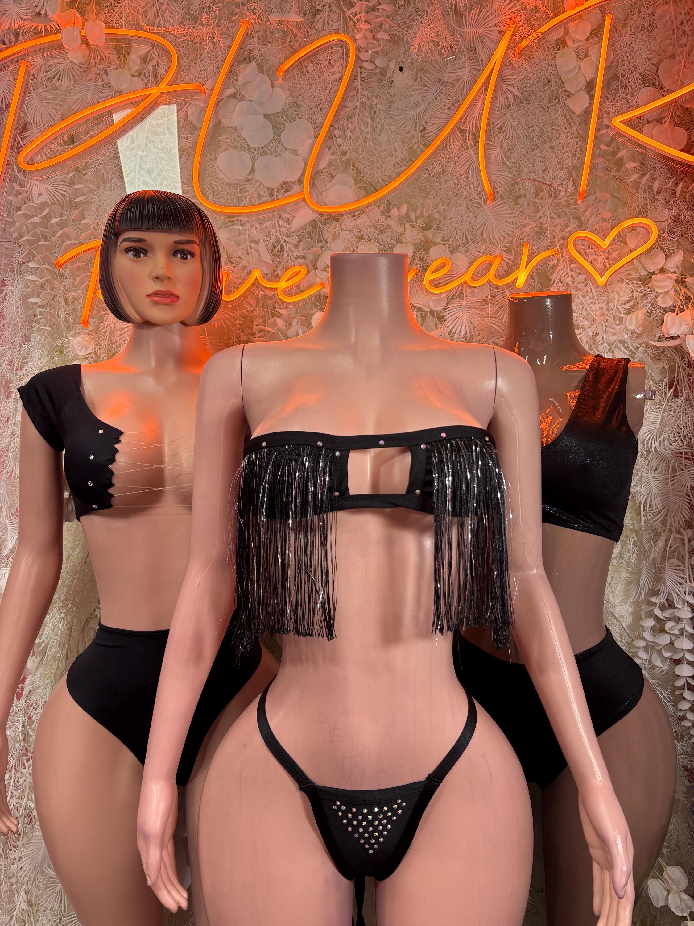 Black two-piece festival outfit, close-up: fringe crop top and studded thong
