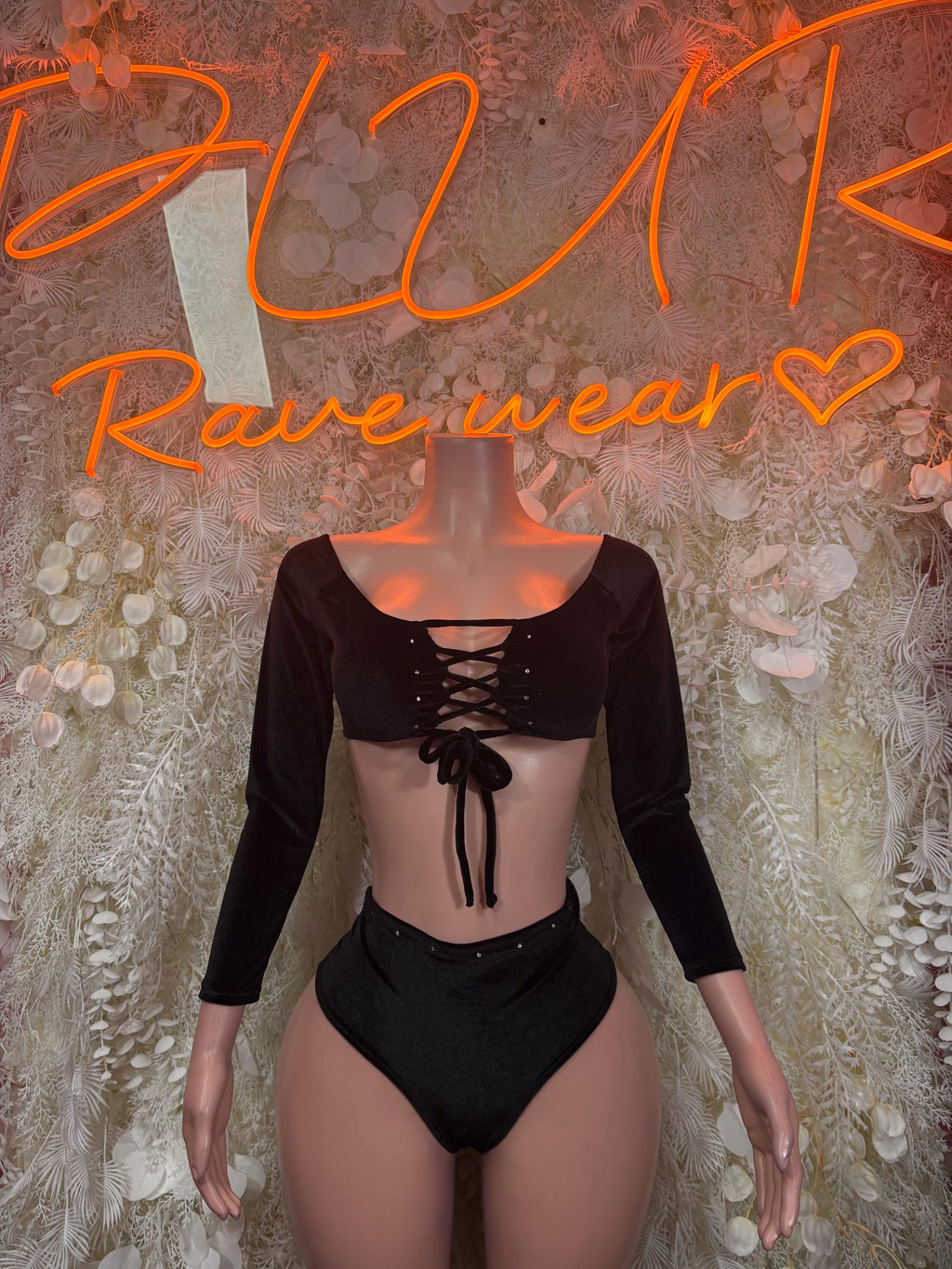 Black long-sleeve crop top and high-cut bottoms with lace-up front detail