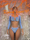 Blue two-piece set with long-sleeve crop top and lace-up bikini bottoms, front view