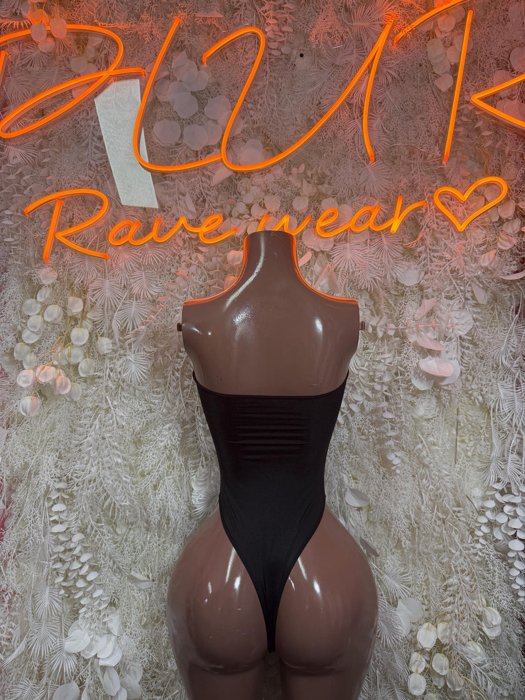 Black cutout bodysuit with high-rise front and open chest cutouts on mannequin
