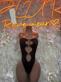 Black cutout bodysuit with heart-shaped chest cutout and central thong opening on mannequin