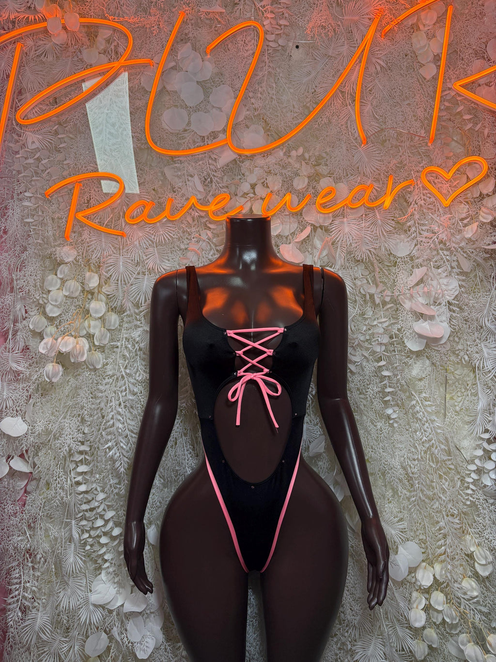 Black bodysuit with neon pink lace-up neckline and open chest cutout