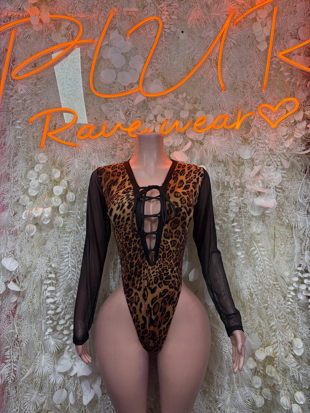 Leopard-print one-piece bodysuit with black sheer sleeves and lace-up neckline