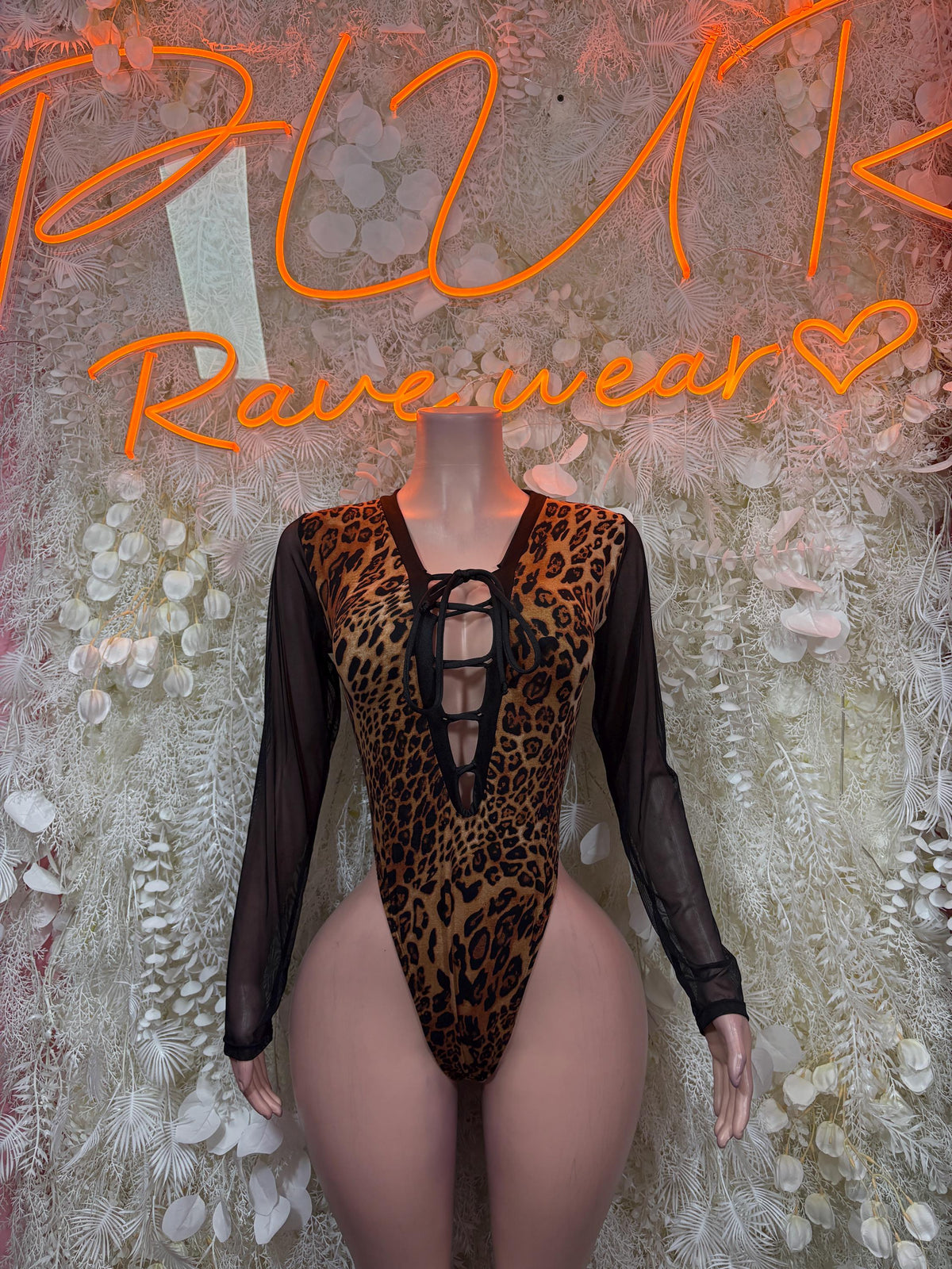 Leopard-print one-piece bodysuit with black sheer sleeves and lace-up neckline