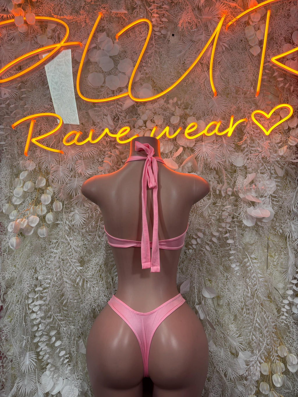 Baby pink rave two-piece set with open-back halter top and bow tie straps, high-cut bottoms