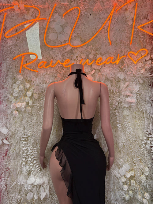 Black open-back halter gown with tie at neck and ruffled asymmetrical hem
