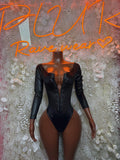 Black long-sleeve bodysuit with lace-up front and high-cut leg openings
