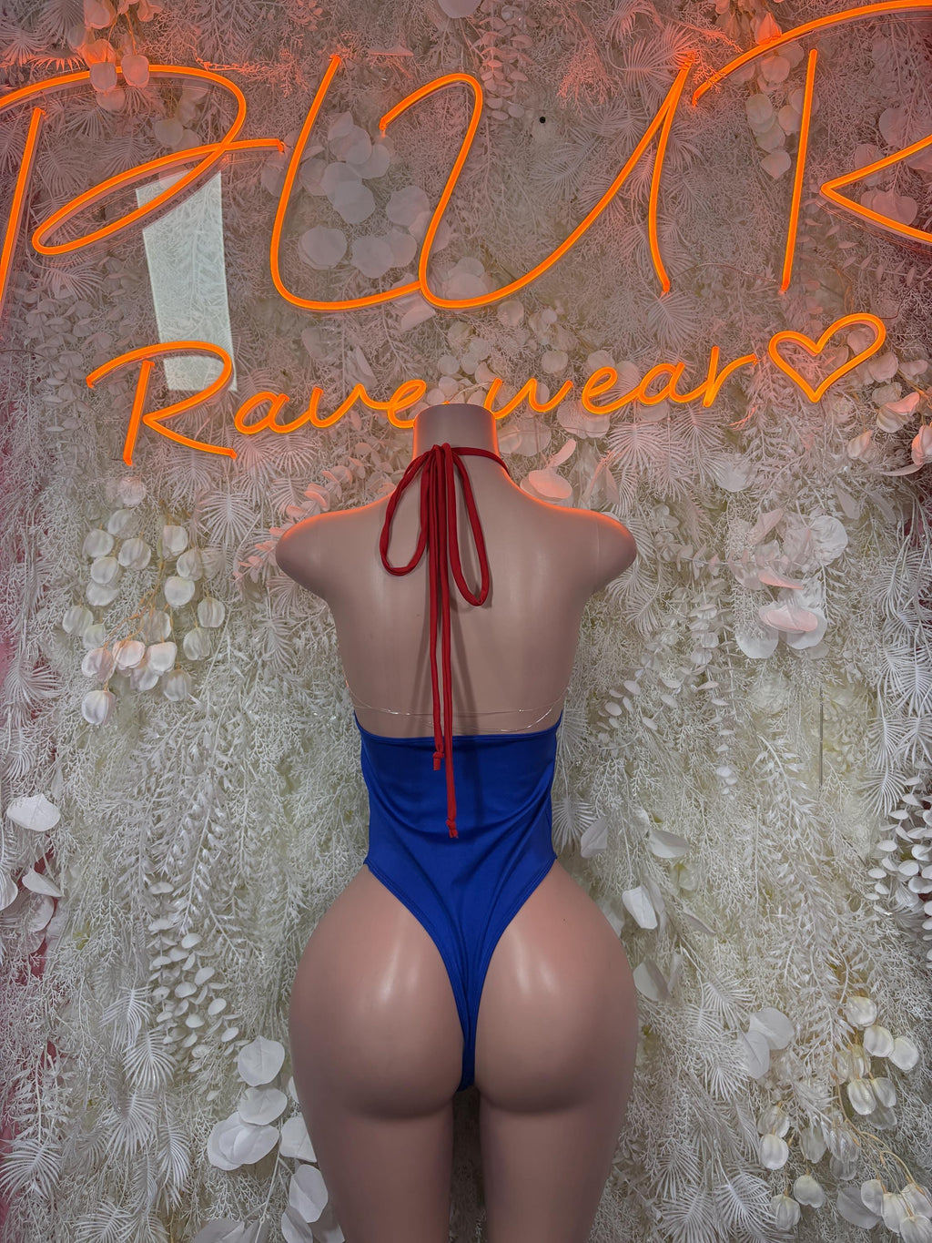 Blue backless one-piece bodysuit with red tie straps at neck and back