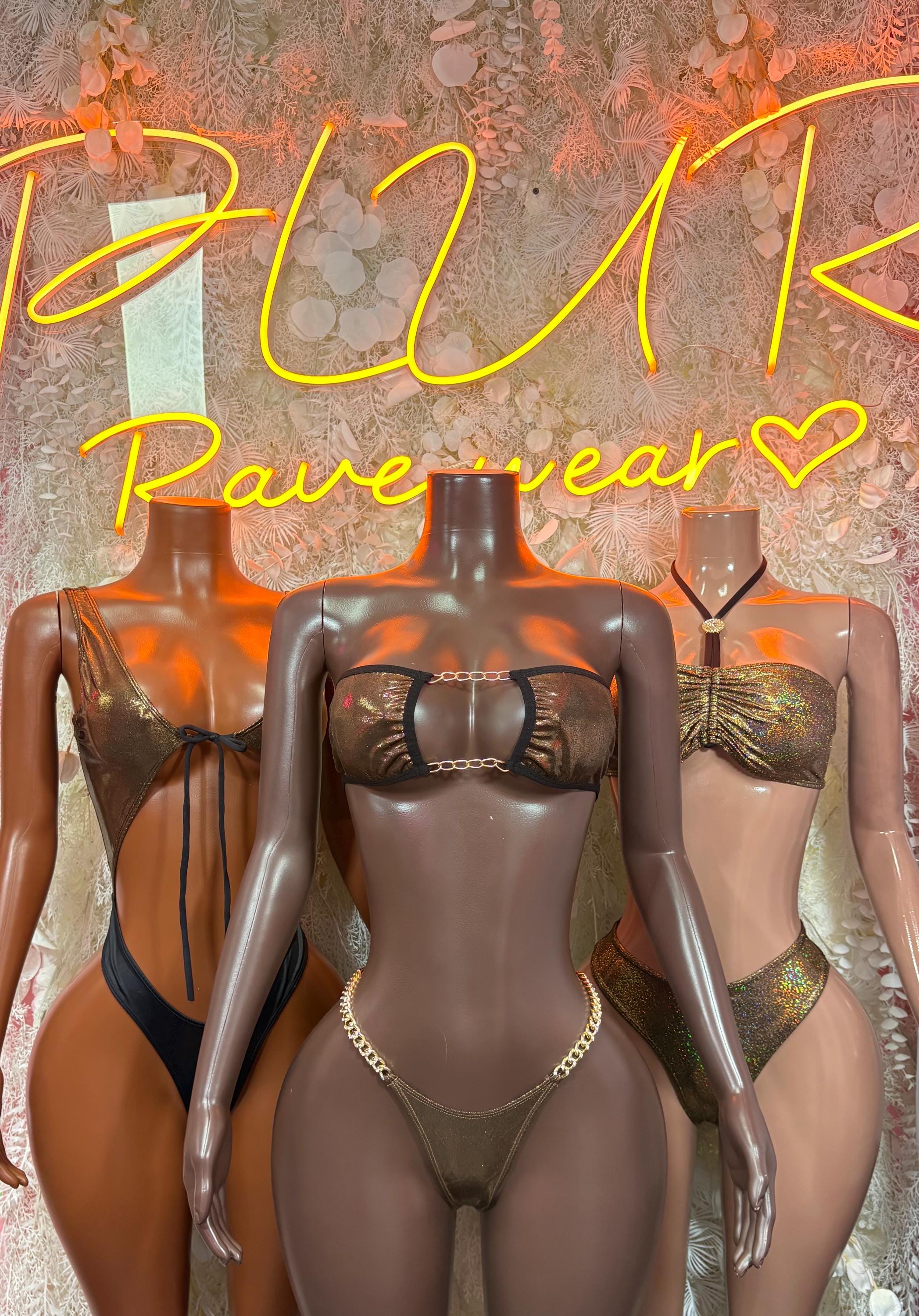 Three metallic chain bikini sets on mannequins: central dark, side gold and dark styles.